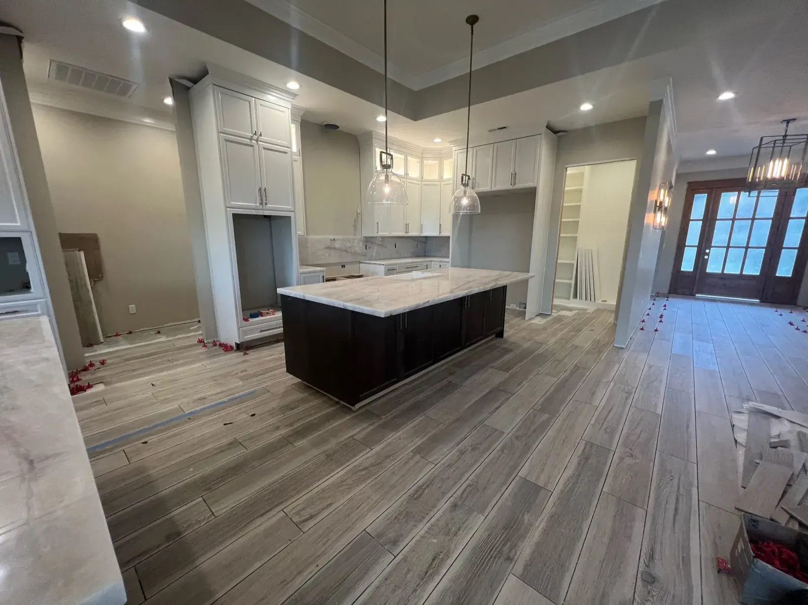 Master bathroom with a freestanding soaking tub centered on wood-look tile floors and a custom vanity