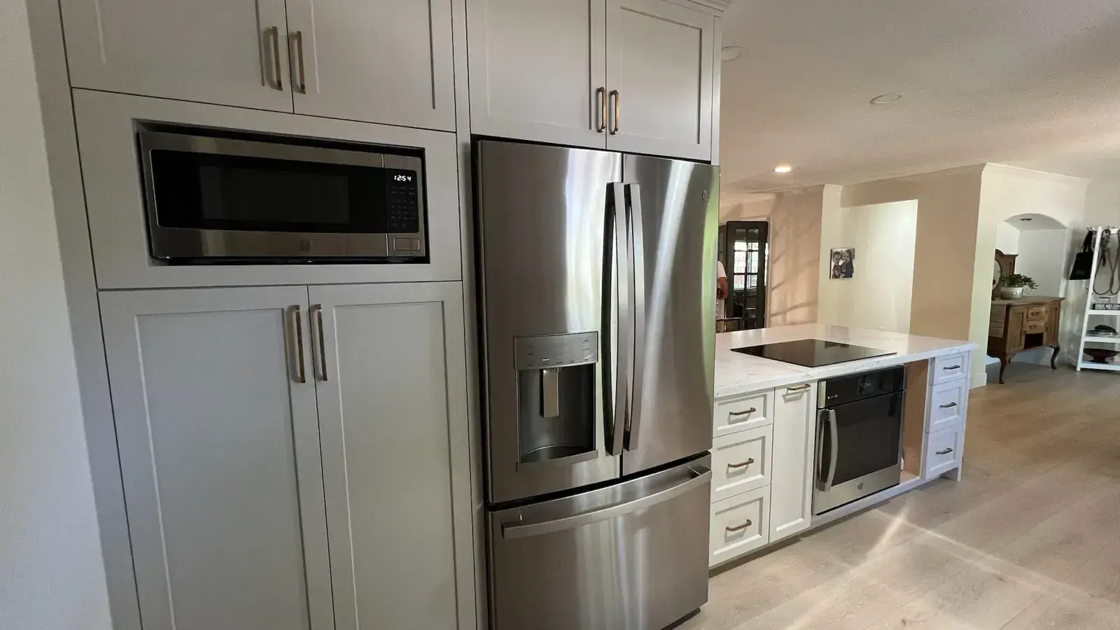 After: Bright kitchen after remodel with gray shaker cabinets and light flooring