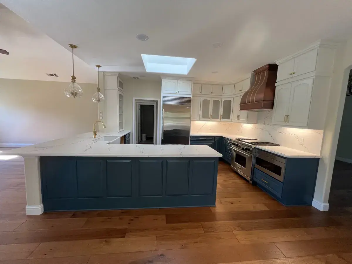 Two-tone kitchen with a blue island and painted cabinets installed by Barron's